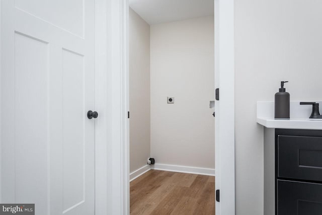 washroom with light hardwood / wood-style floors and hookup for an electric dryer