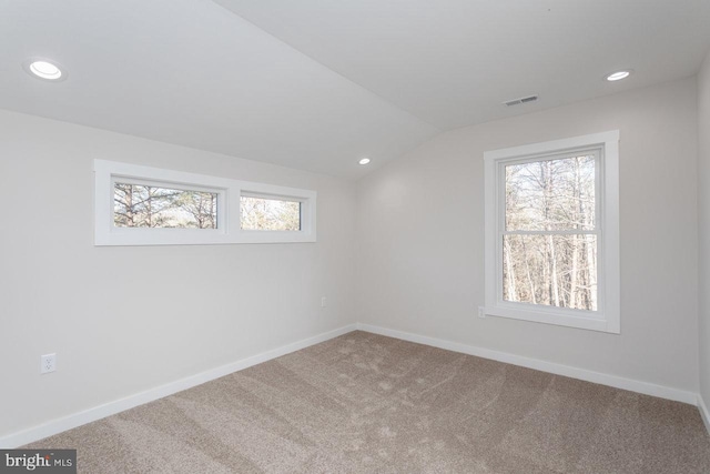 unfurnished room featuring lofted ceiling and carpet flooring