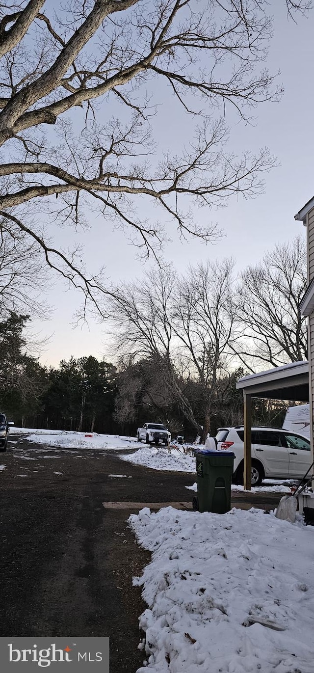 snowy yard featuring a carport