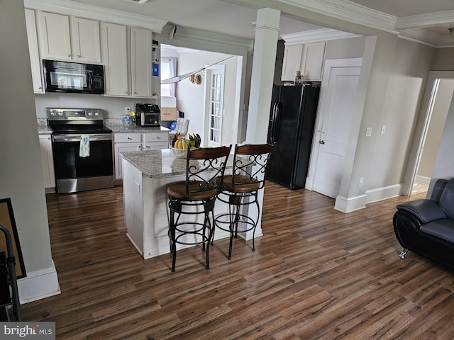 kitchen featuring a breakfast bar, white cabinets, dark hardwood / wood-style flooring, light stone counters, and black appliances