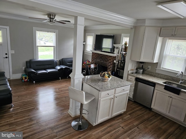 kitchen featuring white cabinetry, a center island, dishwasher, and ornate columns