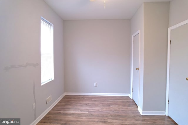 empty room with hardwood / wood-style flooring and a healthy amount of sunlight