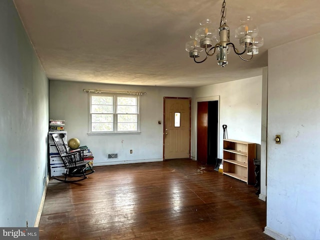 unfurnished room featuring dark hardwood / wood-style floors and an inviting chandelier