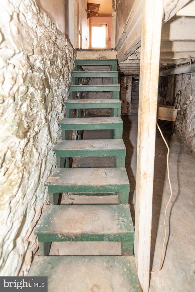 stairs with concrete flooring