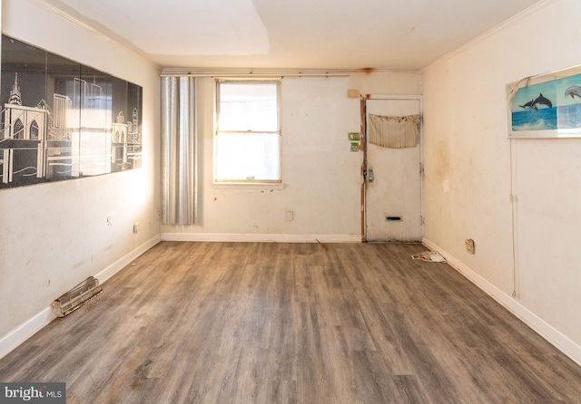 spare room featuring crown molding and dark hardwood / wood-style floors