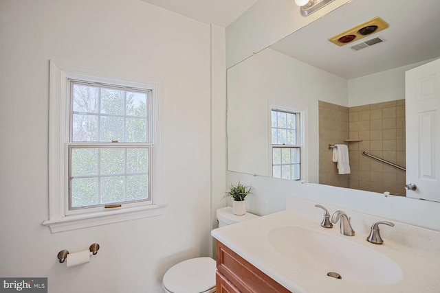 full bathroom featuring visible vents, toilet, vanity, and tiled shower