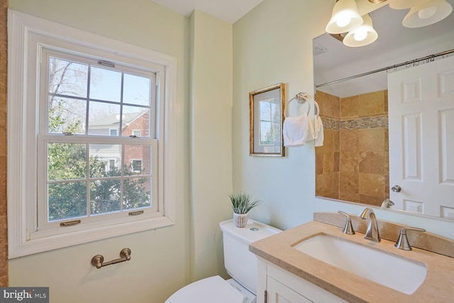 bathroom featuring toilet, walk in shower, and vanity