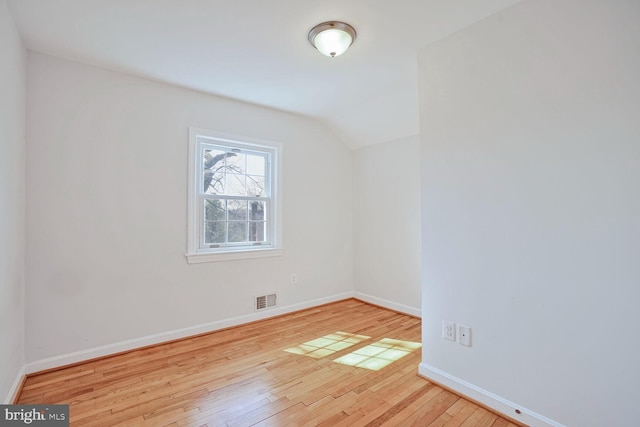 bonus room with vaulted ceiling, baseboards, visible vents, and wood-type flooring