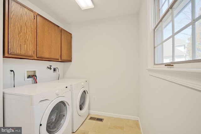 washroom featuring light tile patterned floors, visible vents, baseboards, cabinet space, and independent washer and dryer