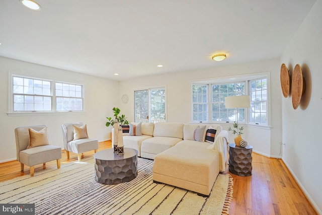 living room with recessed lighting, light wood-type flooring, and baseboards