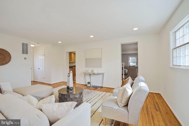 living area featuring recessed lighting, visible vents, light wood finished floors, and baseboards