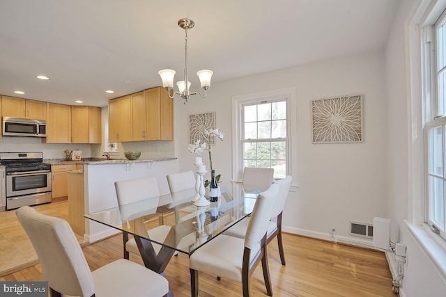 dining space with visible vents, baseboards, recessed lighting, a notable chandelier, and light wood-type flooring