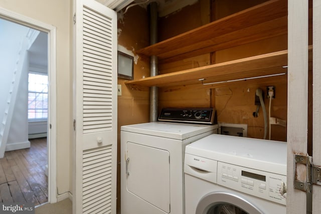 clothes washing area with washer and dryer, hardwood / wood-style floors, and baseboard heating