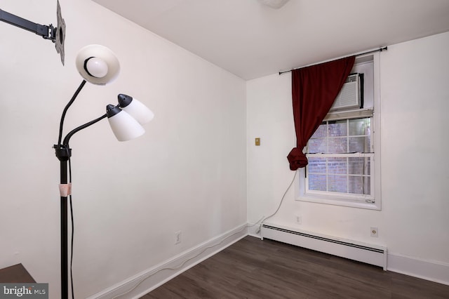 unfurnished room featuring a baseboard radiator and dark hardwood / wood-style floors