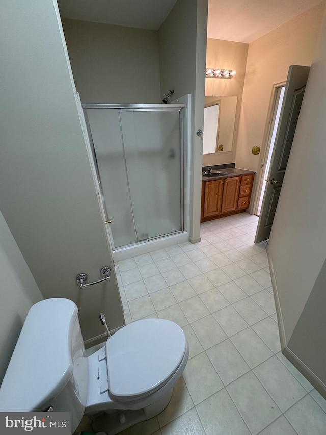 bathroom featuring vanity, tile patterned floors, toilet, and walk in shower