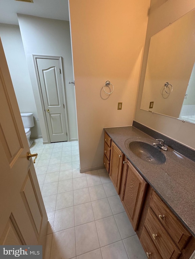 bathroom featuring vanity, tile patterned floors, and toilet