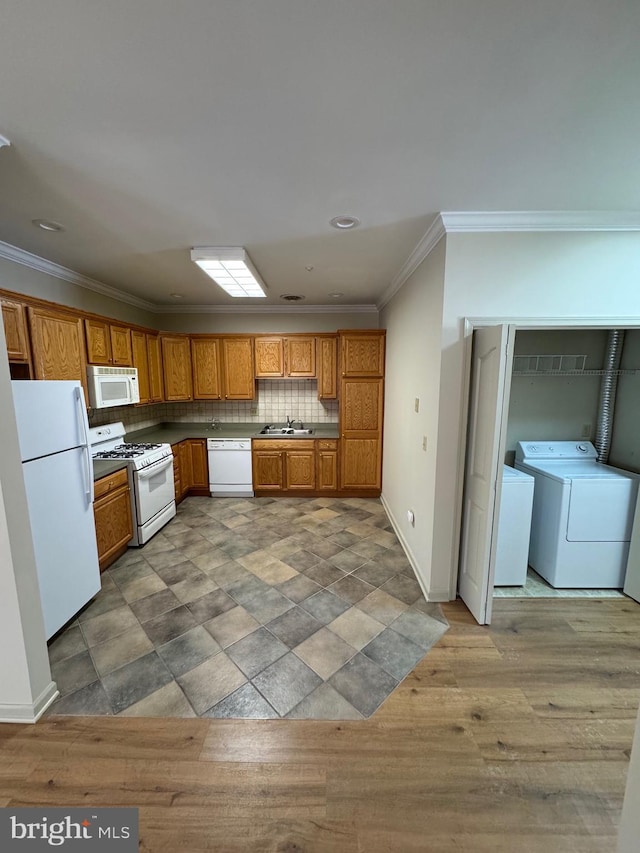 kitchen featuring crown molding, white appliances, decorative backsplash, and washing machine and clothes dryer