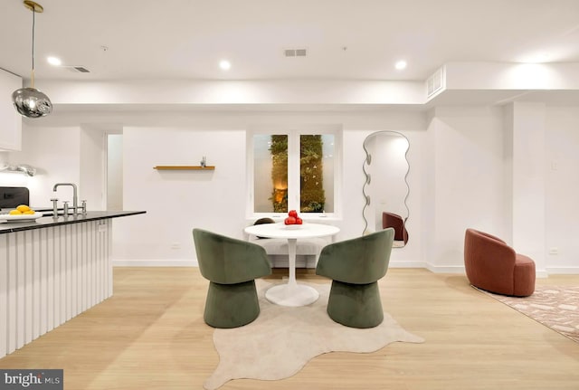 dining area featuring sink and light wood-type flooring