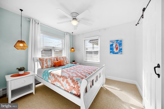 carpeted bedroom with a baseboard radiator, a barn door, and ceiling fan