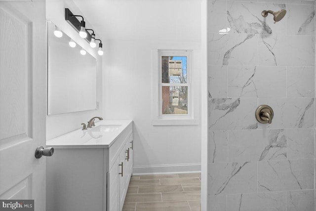 bathroom featuring tiled shower and vanity