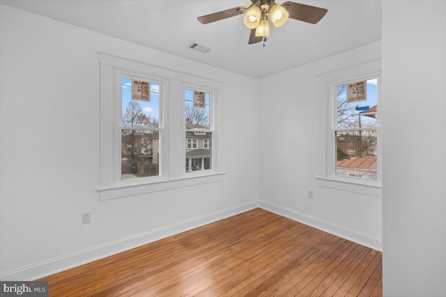 spare room with hardwood / wood-style flooring, a wealth of natural light, and ceiling fan