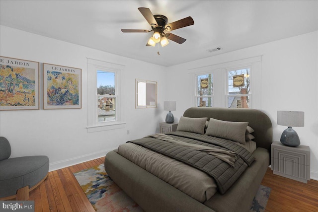 bedroom with ceiling fan, hardwood / wood-style floors, and multiple windows