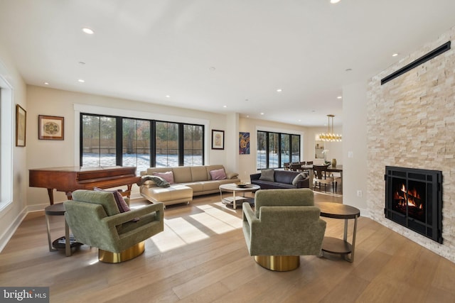 living room with a wealth of natural light, a fireplace, and light hardwood / wood-style floors