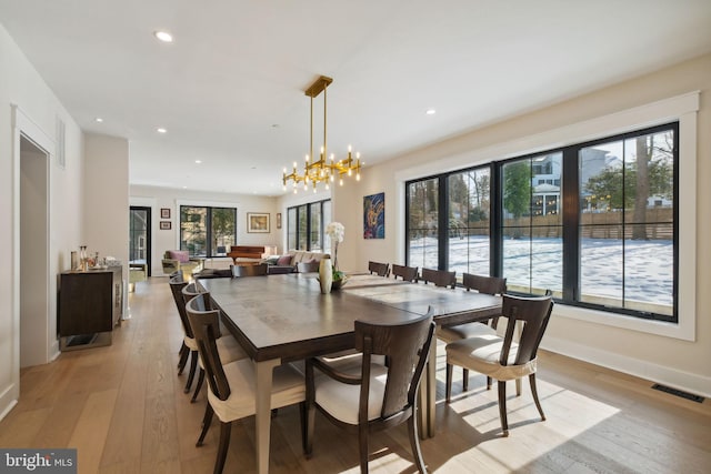 dining room featuring an inviting chandelier and light hardwood / wood-style flooring