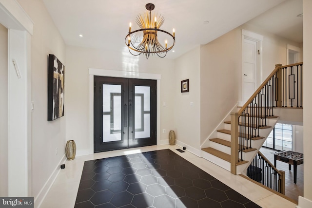 tiled entrance foyer with an inviting chandelier and french doors