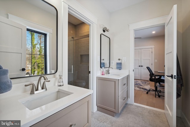 bathroom with vanity, toilet, and a tile shower