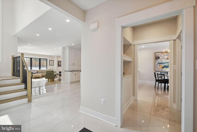 hall featuring light tile patterned floors and built in shelves