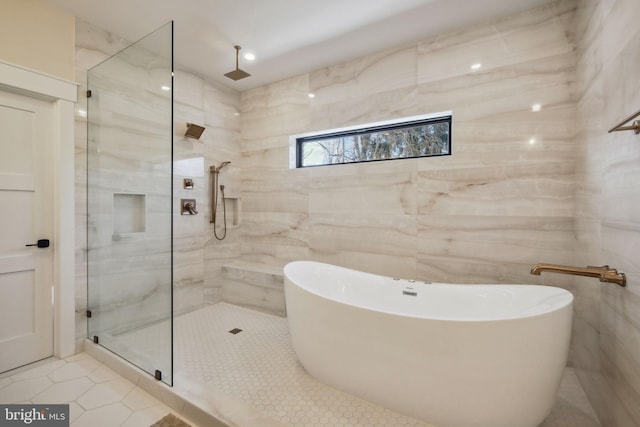 bathroom featuring tile patterned flooring, plus walk in shower, and tile walls