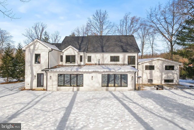 view of snow covered back of property