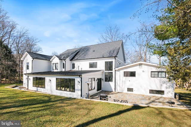 rear view of house with a yard and a patio area