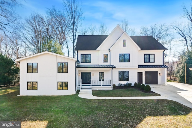 modern farmhouse featuring a garage, a front yard, and covered porch