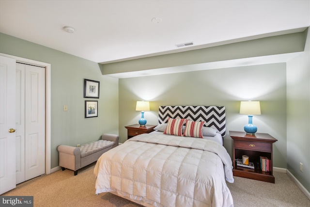 bedroom with light carpet and a closet