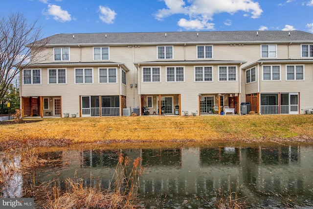 rear view of property with a water view and central AC