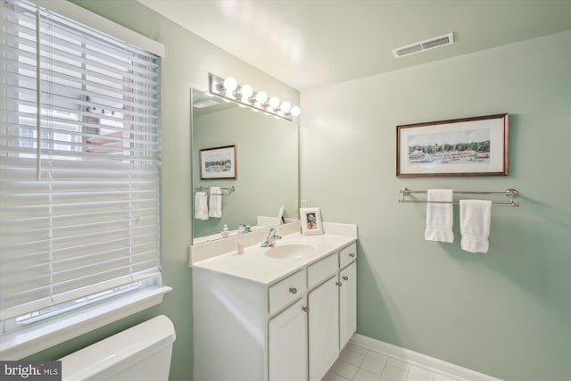 bathroom with vanity, plenty of natural light, tile patterned floors, and toilet