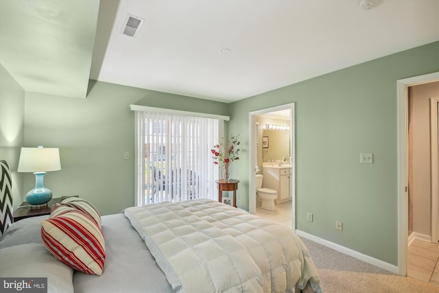 carpeted bedroom featuring access to outside and ensuite bath