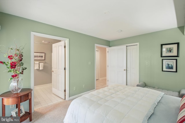 tiled bedroom featuring connected bathroom and a closet