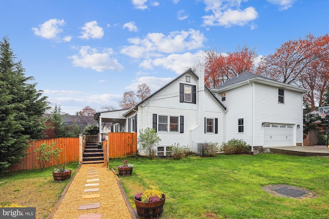 rear view of house with a garage and a lawn