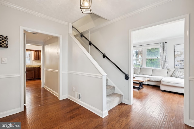 stairway featuring ornamental molding and hardwood / wood-style floors