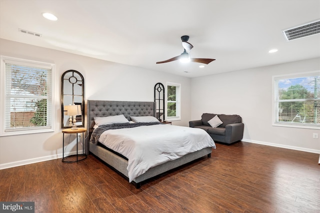 bedroom featuring ceiling fan, dark hardwood / wood-style flooring, and multiple windows