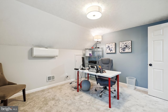 office space with lofted ceiling, light colored carpet, an AC wall unit, and a textured ceiling