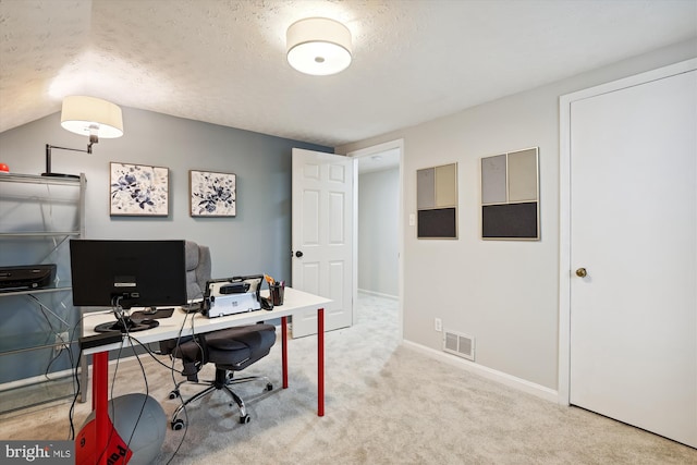 carpeted office featuring a textured ceiling