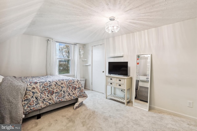 carpeted bedroom featuring vaulted ceiling and a textured ceiling