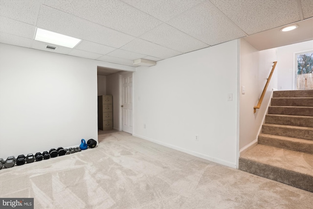 basement with light colored carpet and a drop ceiling