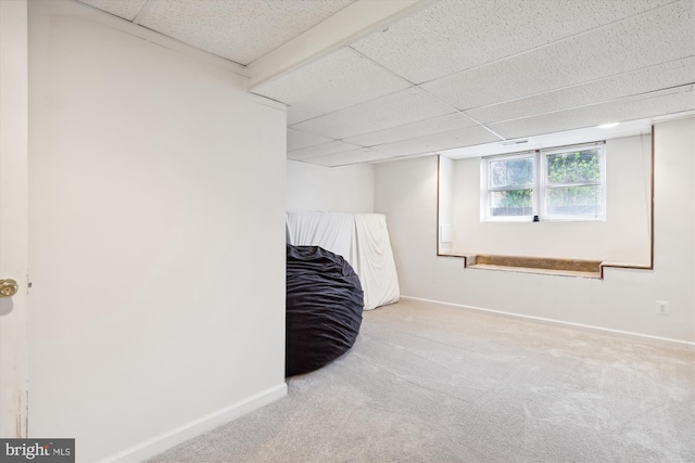 bedroom featuring a paneled ceiling and light colored carpet