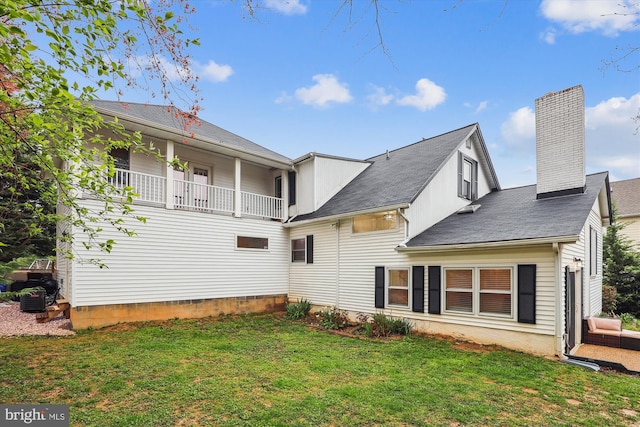 back of property featuring a yard and a balcony