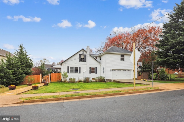 view of property with a garage and a front lawn